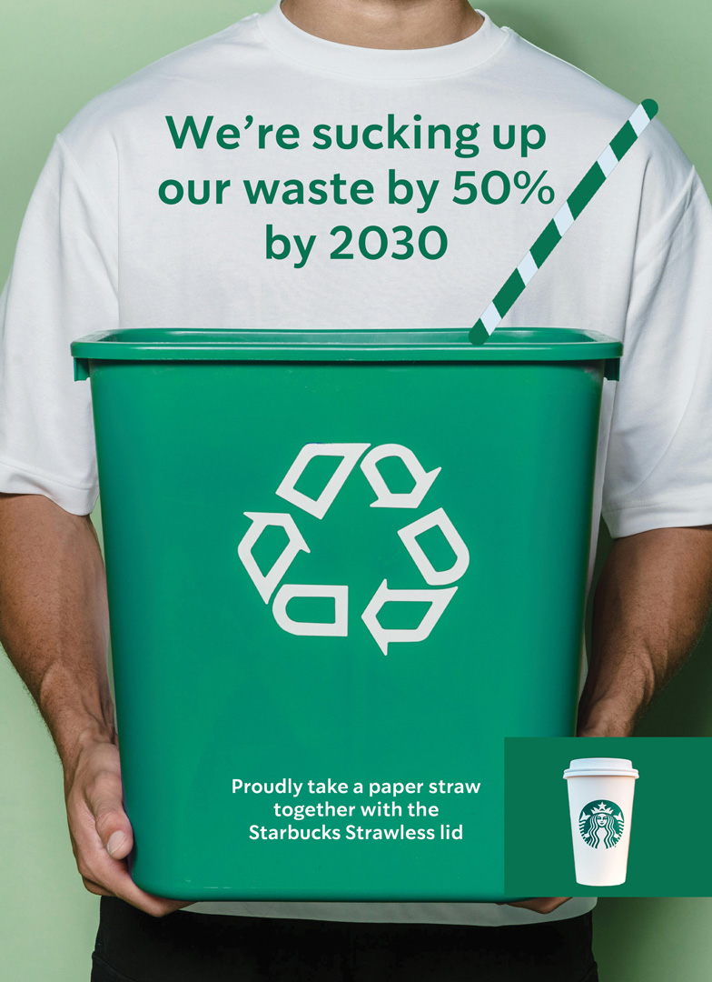 Starbucks paper straw advertisement variant 3. A man holding a recycling bin with a large paper straw sticking out. 'We're sucking up our waste...' tagline.